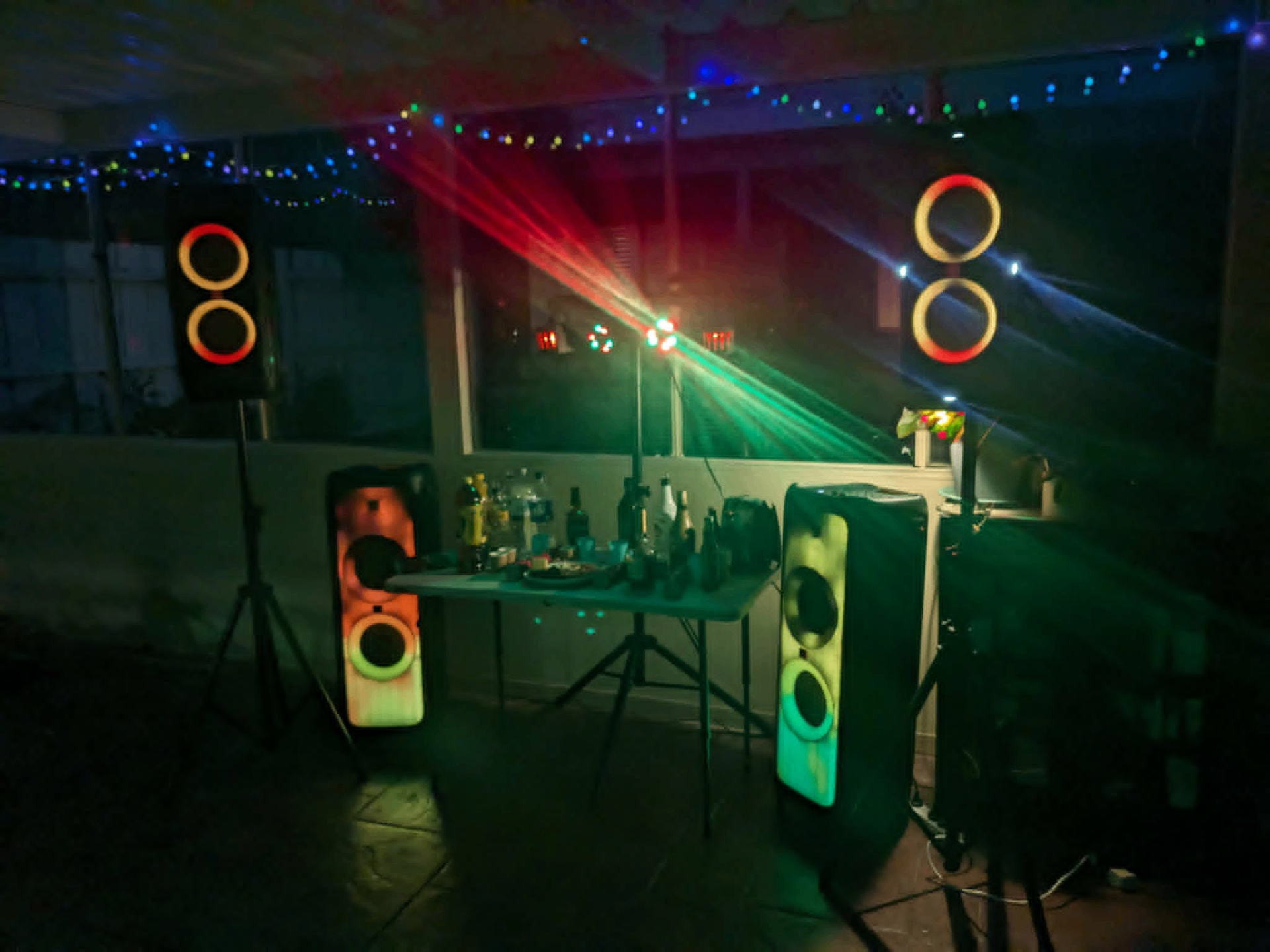Indoor party speaker setup with colourful fairy lights and laser effects