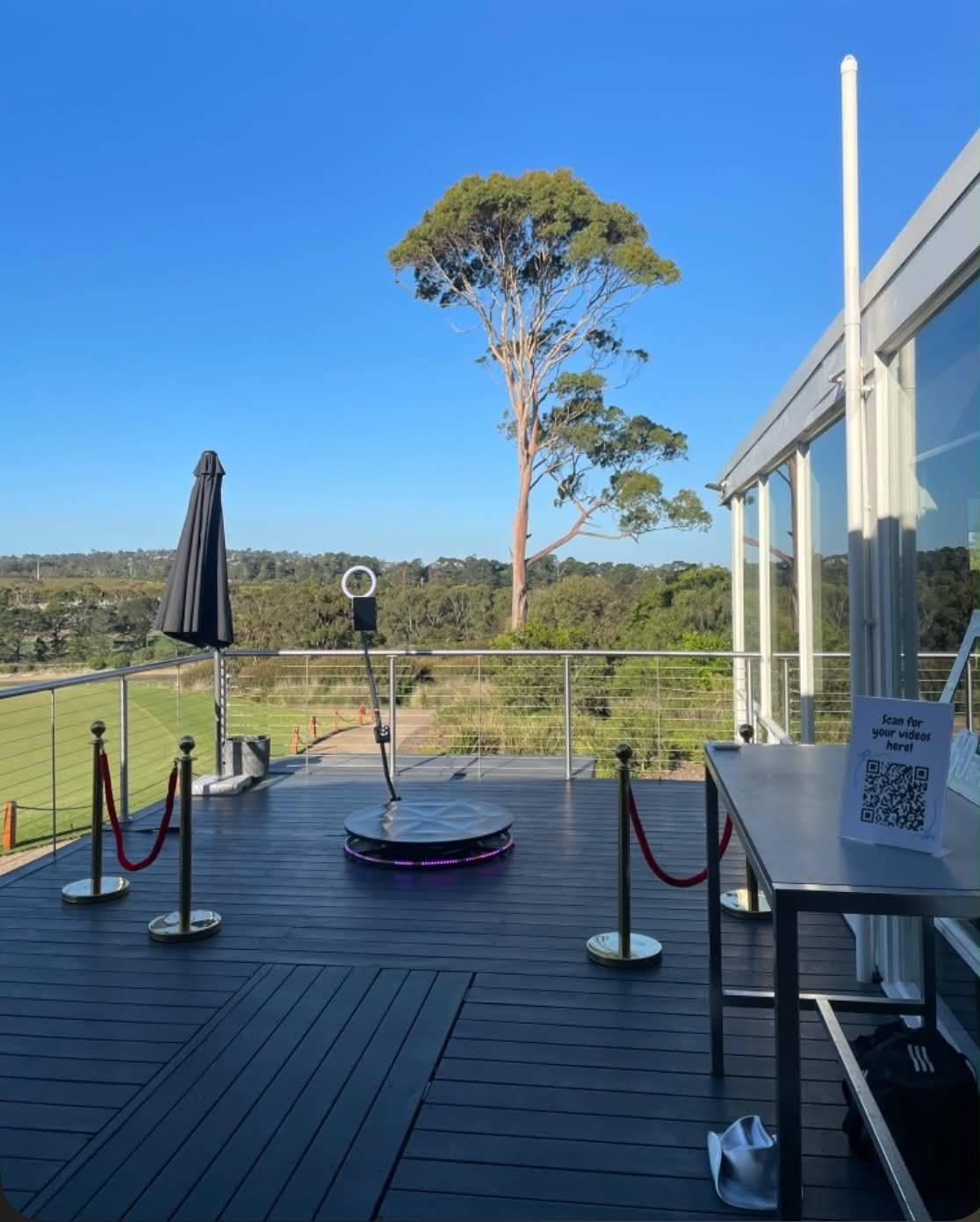Outdoor 360 photo booth setup on a deck overlooking bushland