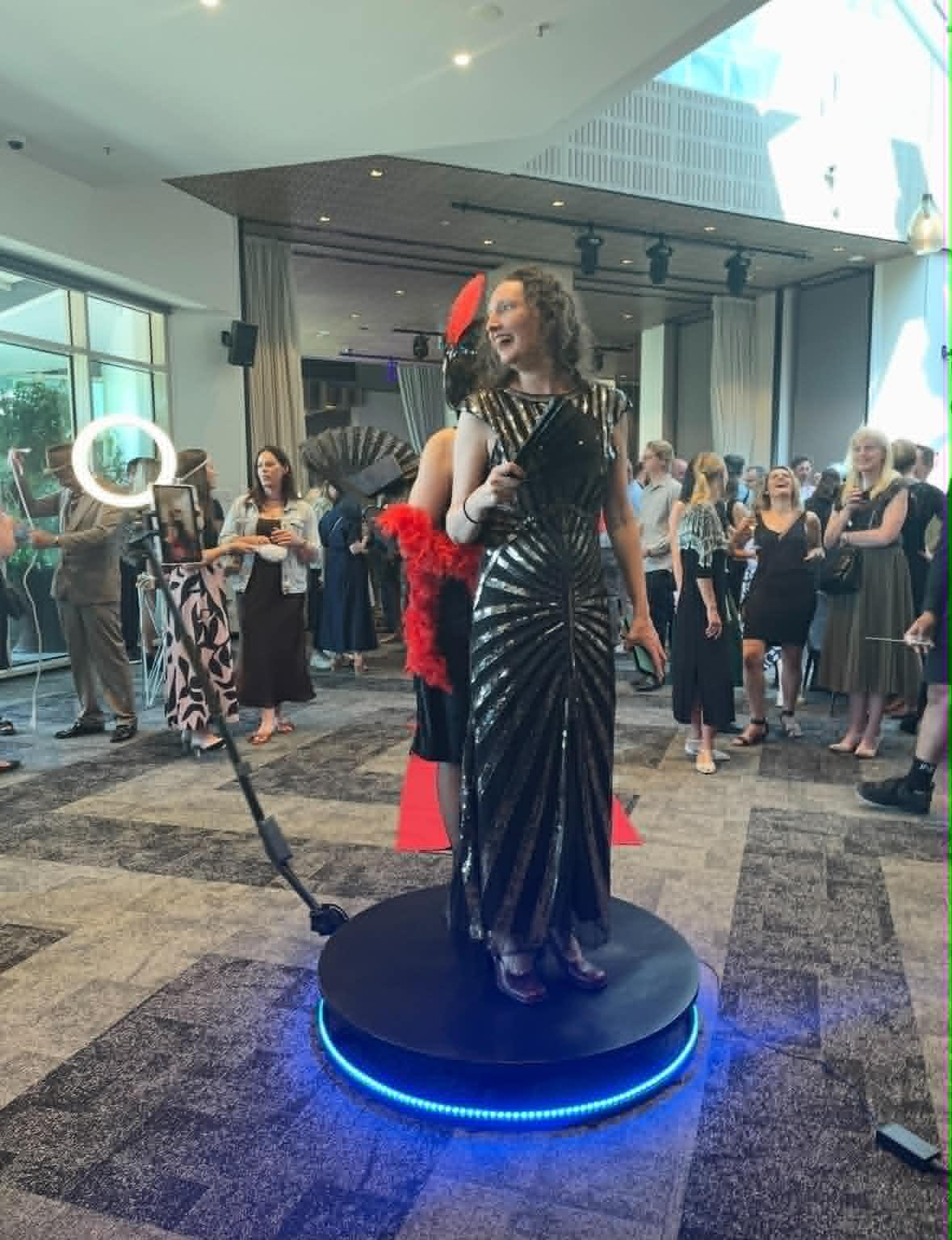 Guest using the 360 photo booth in a formal event setting