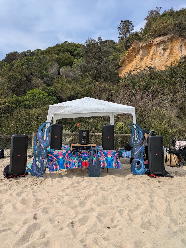 Four party speakers set up under a marquee for a beach event