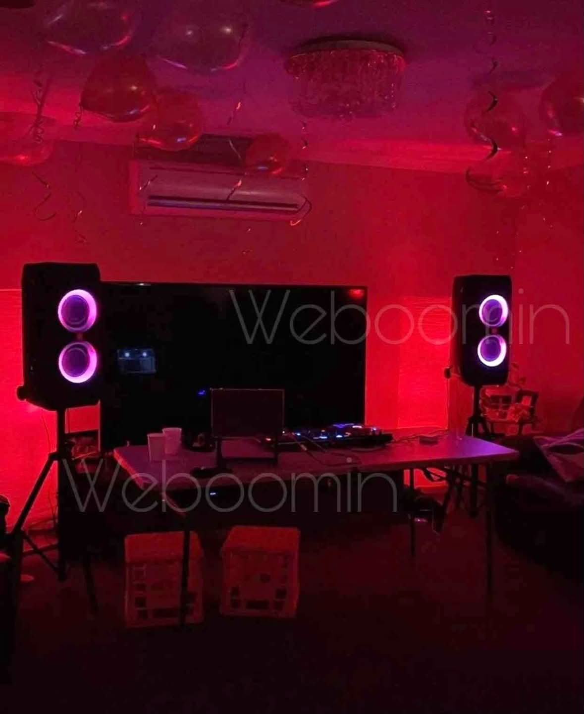 Red-lit DJ and speaker setup for a private event