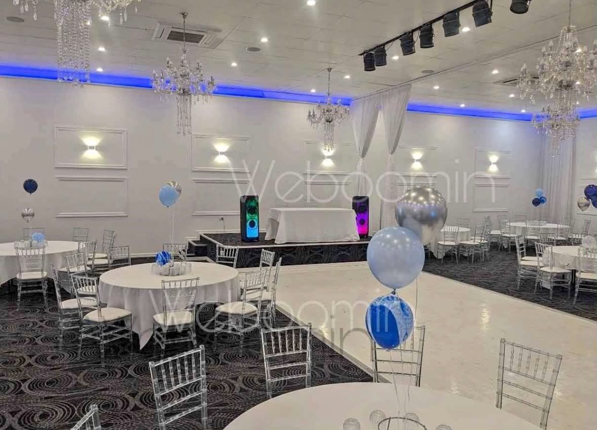 Large ballroom event with speakers lighting the main stage area