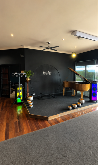 Speaker setup in a function room beside a piano stage